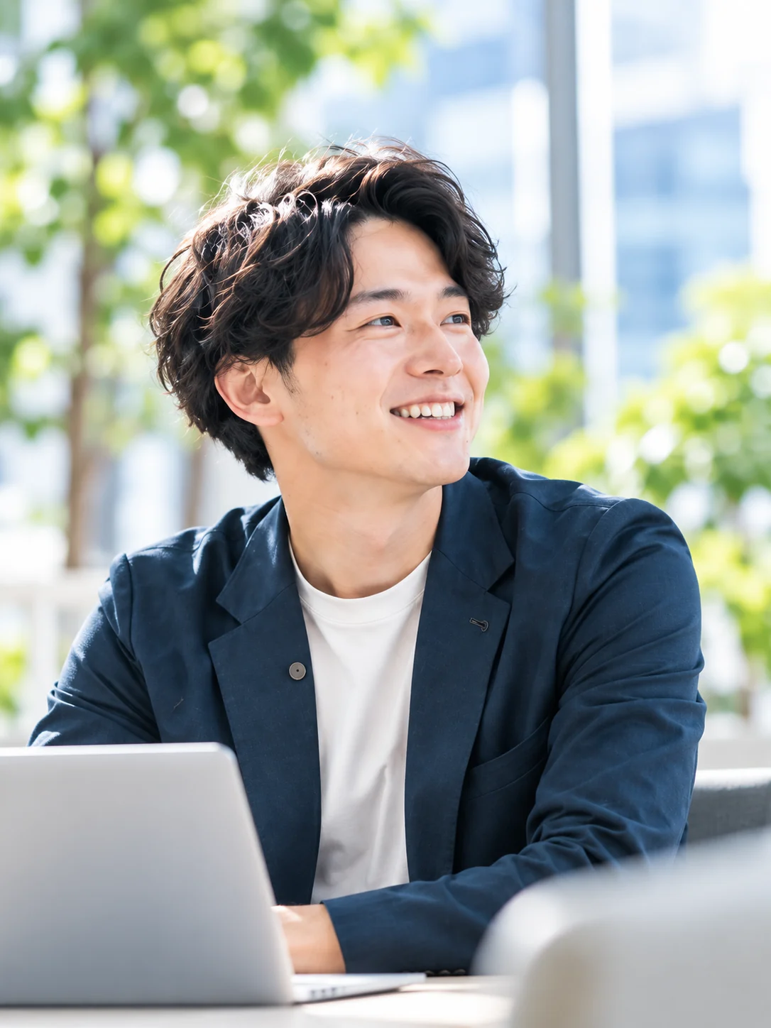 ノートパソコンを前に笑顔を見せる佐藤さん