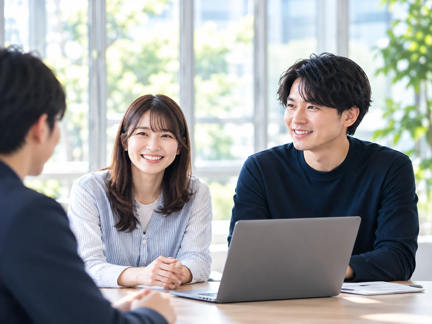 テーブルを囲んで笑顔で話し合う社員たち
