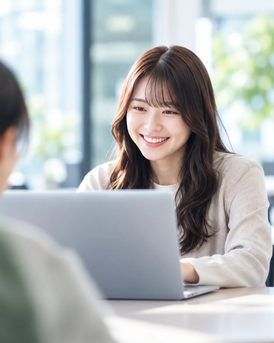 ノートパソコンに向かい、笑顔で学ぶ社員