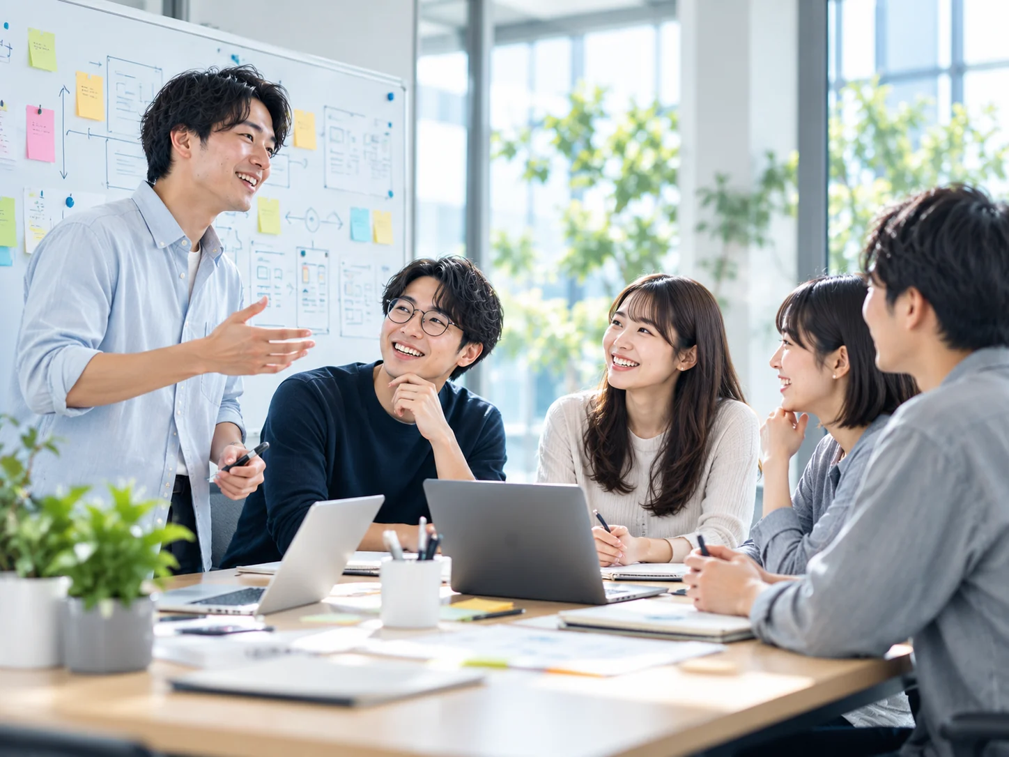 ホワイトボードの前でプロジェクトについて話し合う社員たち